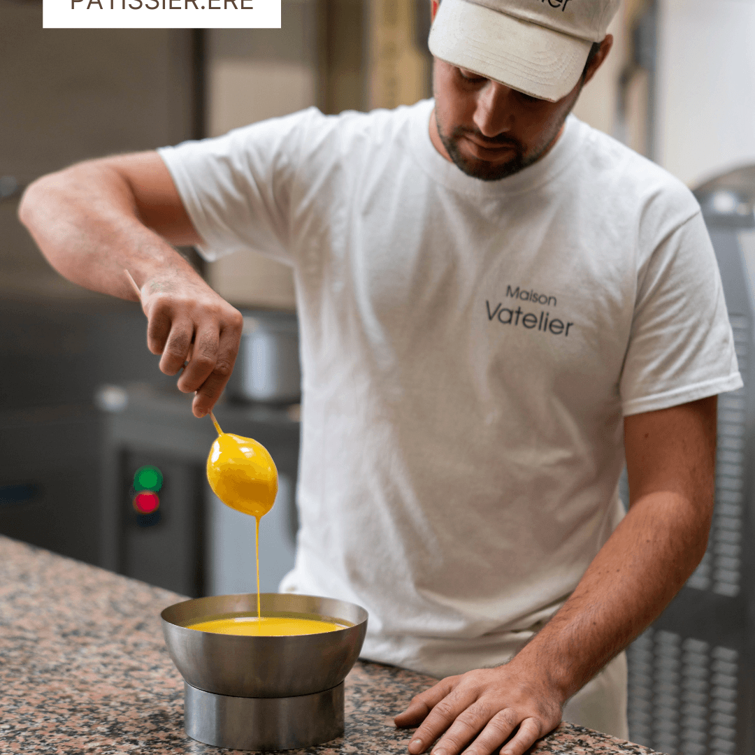 Un pâtissier de la Maison Vatelier préparant une crème jaune dans un bol.