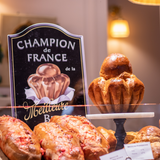 Brioche artisanale dorée et pâtisserie de champion de France présentées en boutique.