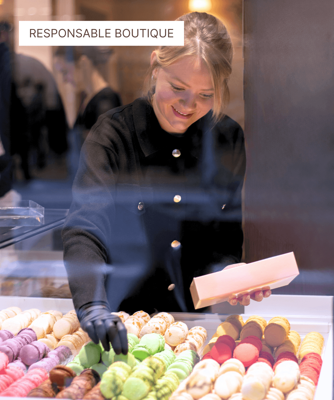 Responsable boutique préparant une boîte de macarons colorés en pâtisserie