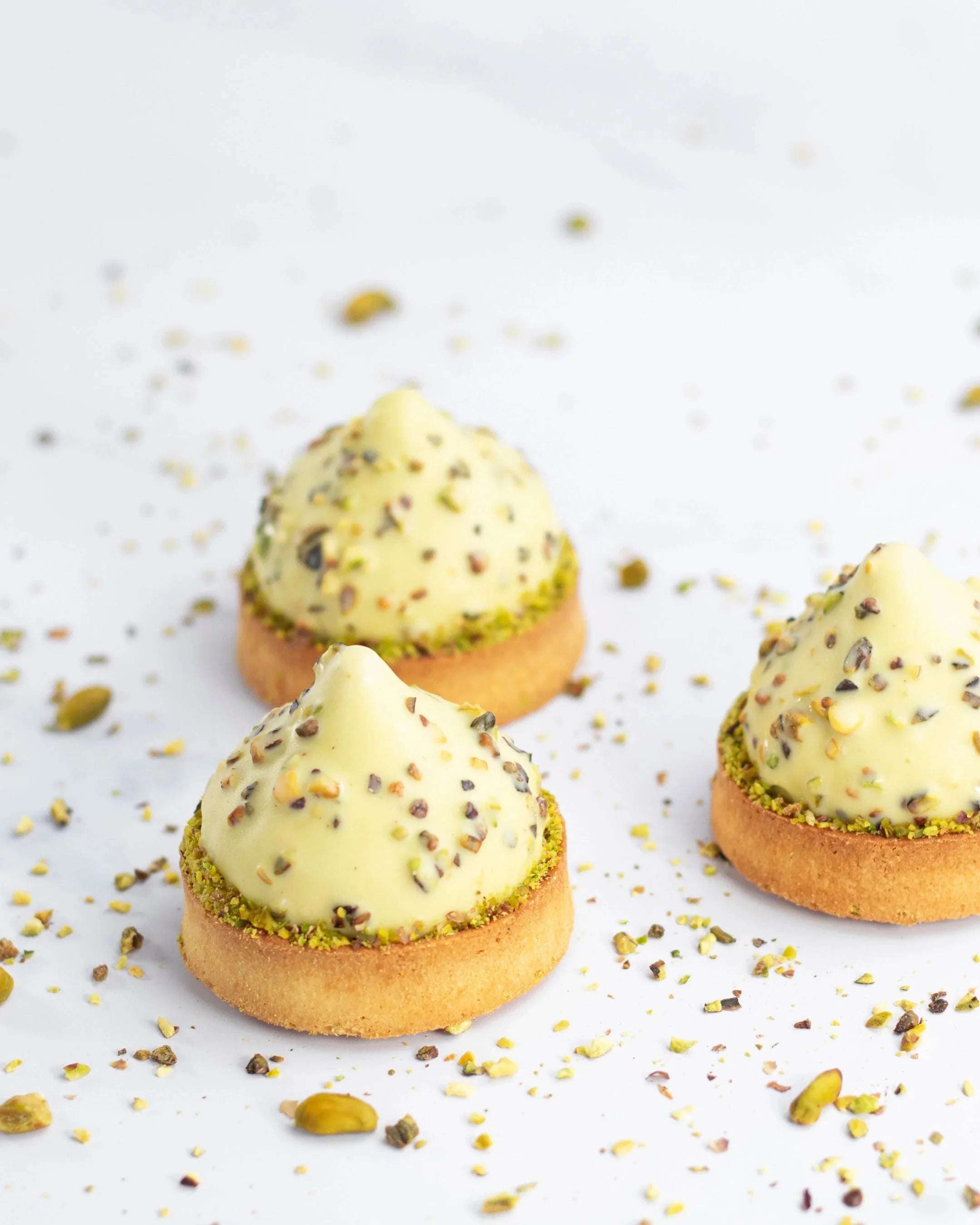 Trois mignardises Pure Pistache de Maison Vatelier avec crème et éclats de pistaches.