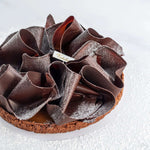 Tarte au caramel beurre salé Maison Vatelier avec copeaux de chocolat et sucre glace.