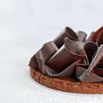 Tarte au caramel beurre salé Maison Vatelier avec copeaux de chocolat et sucre glace.