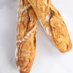 Deux baguettes de tradition Maison Vatelier avec une croûte dorée et croustillante.