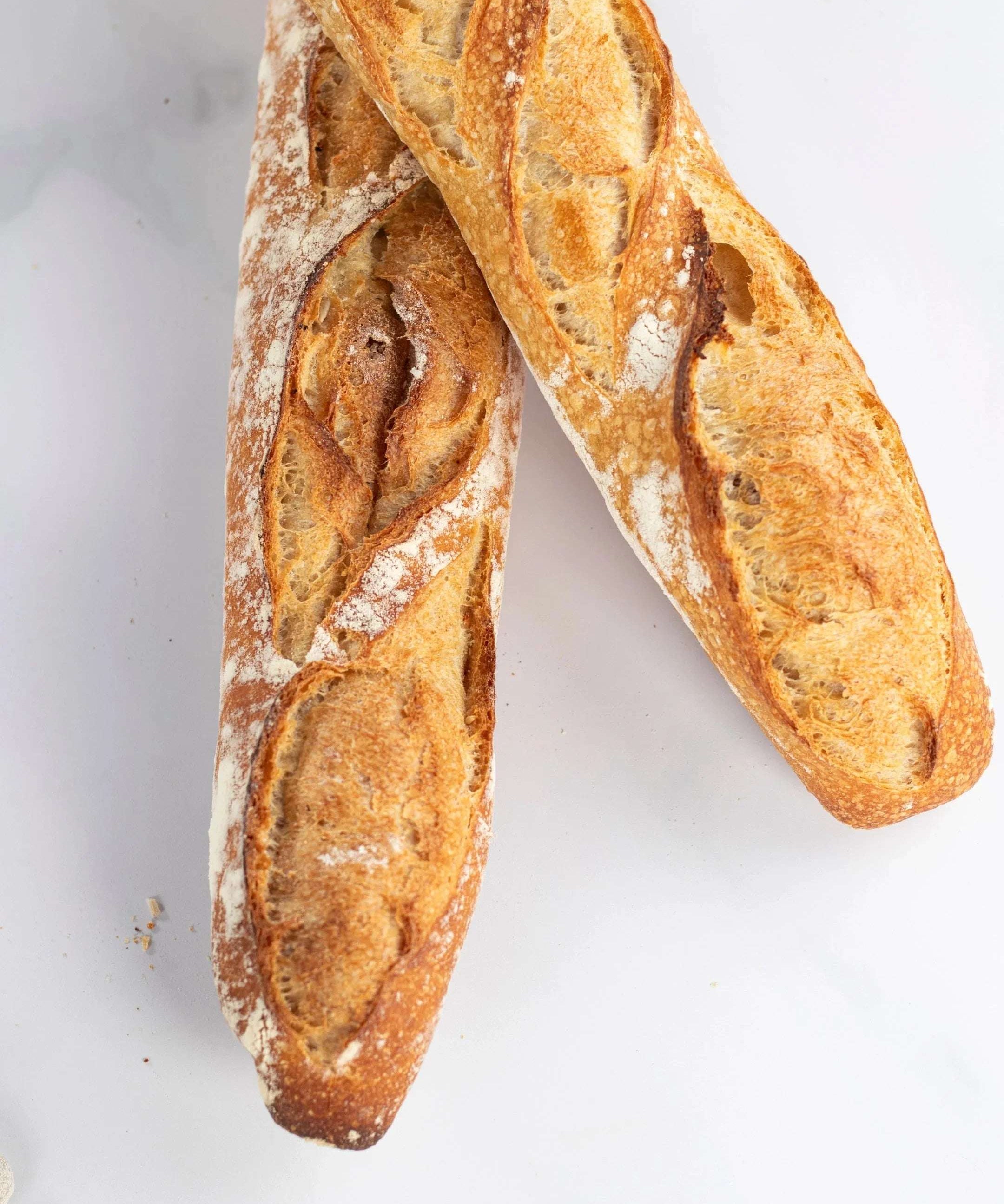 Deux baguettes de tradition Maison Vatelier avec une croûte dorée et croustillante.