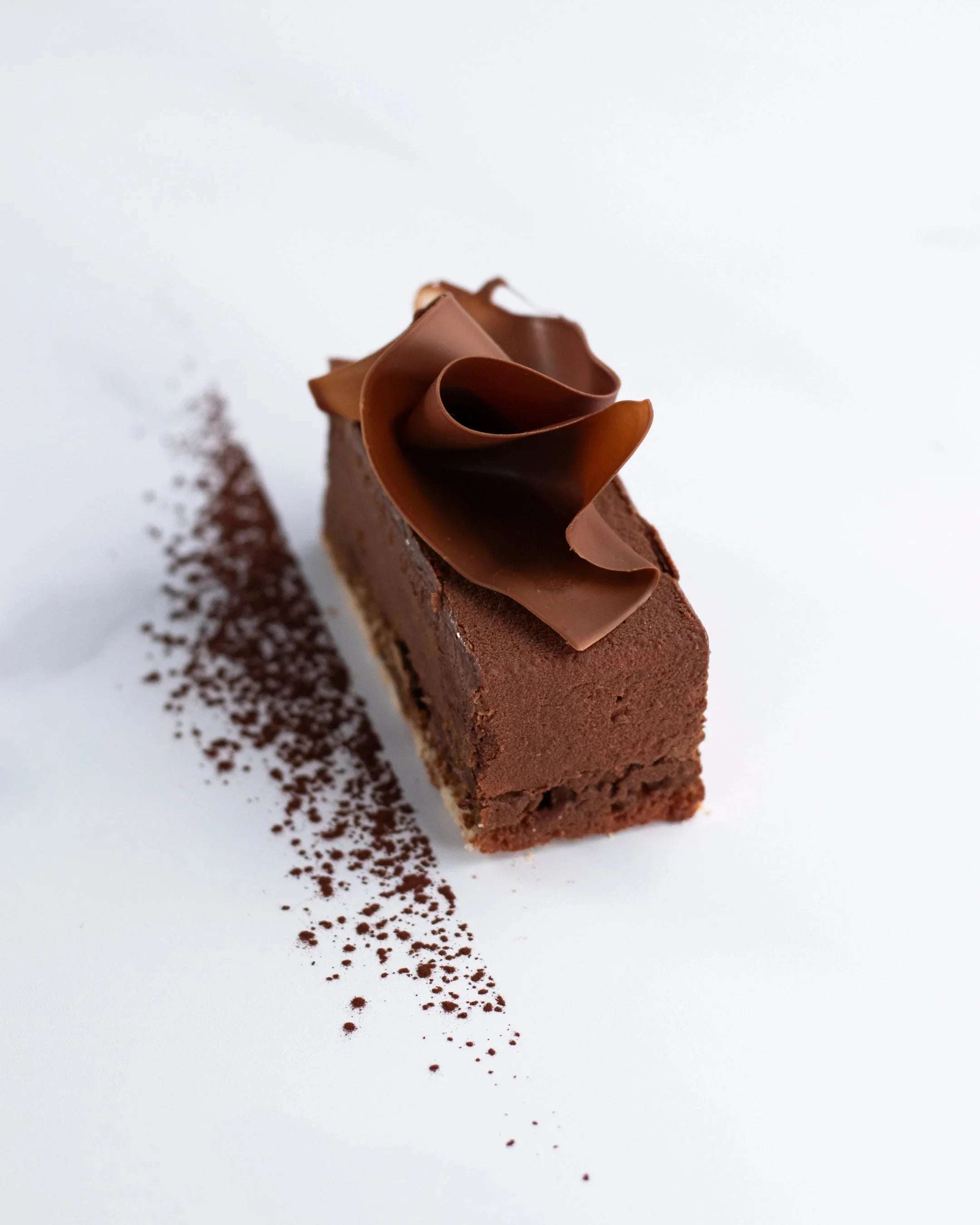 Gâteau Royal au chocolat Maison Vatelier avec copeaux de chocolat sur fond blanc