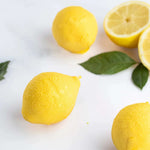 Citrons jaunes frais entiers et coupés avec des feuilles vertes sur fond blanc