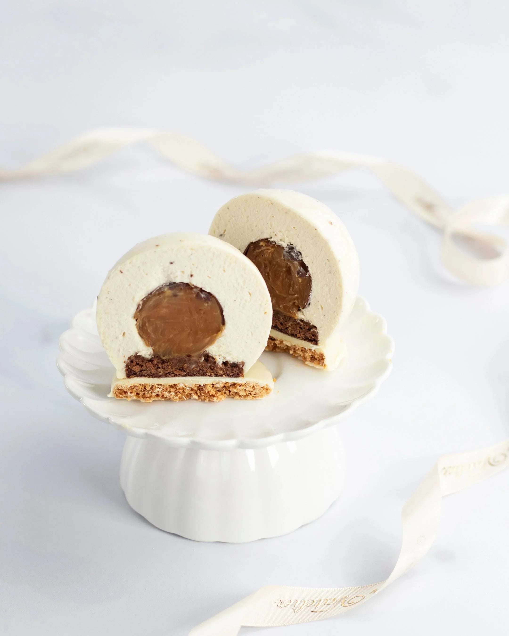 Gâteau Perle de Maison Vatelier coupé en deux, révélant un cœur fondant et un biscuit croustillant.