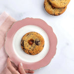 Cookie 3 Chocolats de Maison Vatelier sur une assiette rose avec des cookies en arrière-plan.