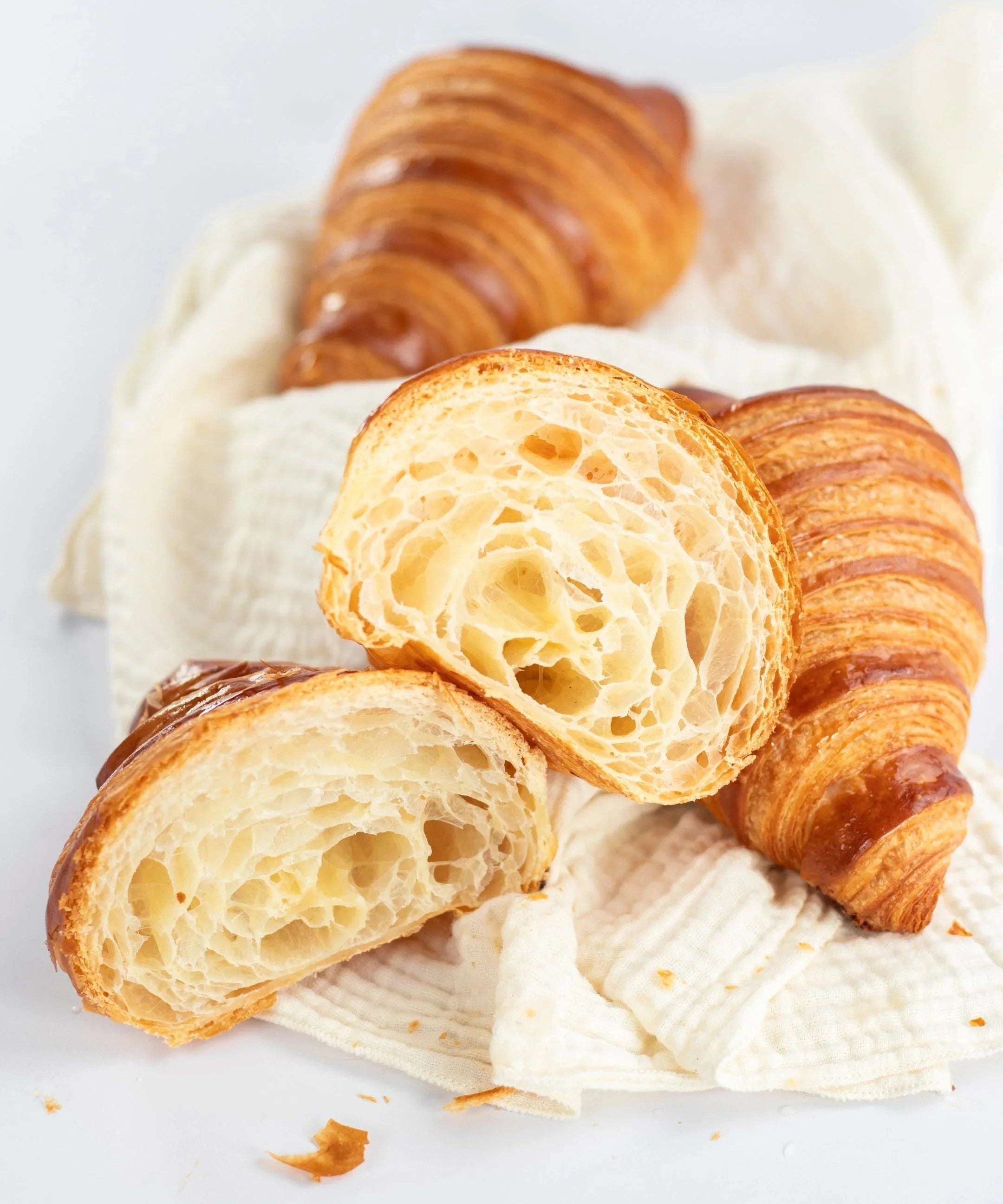 Croissants Maison Vatelier dorés et feuilletés, coupés pour montrer l'alvéolage.