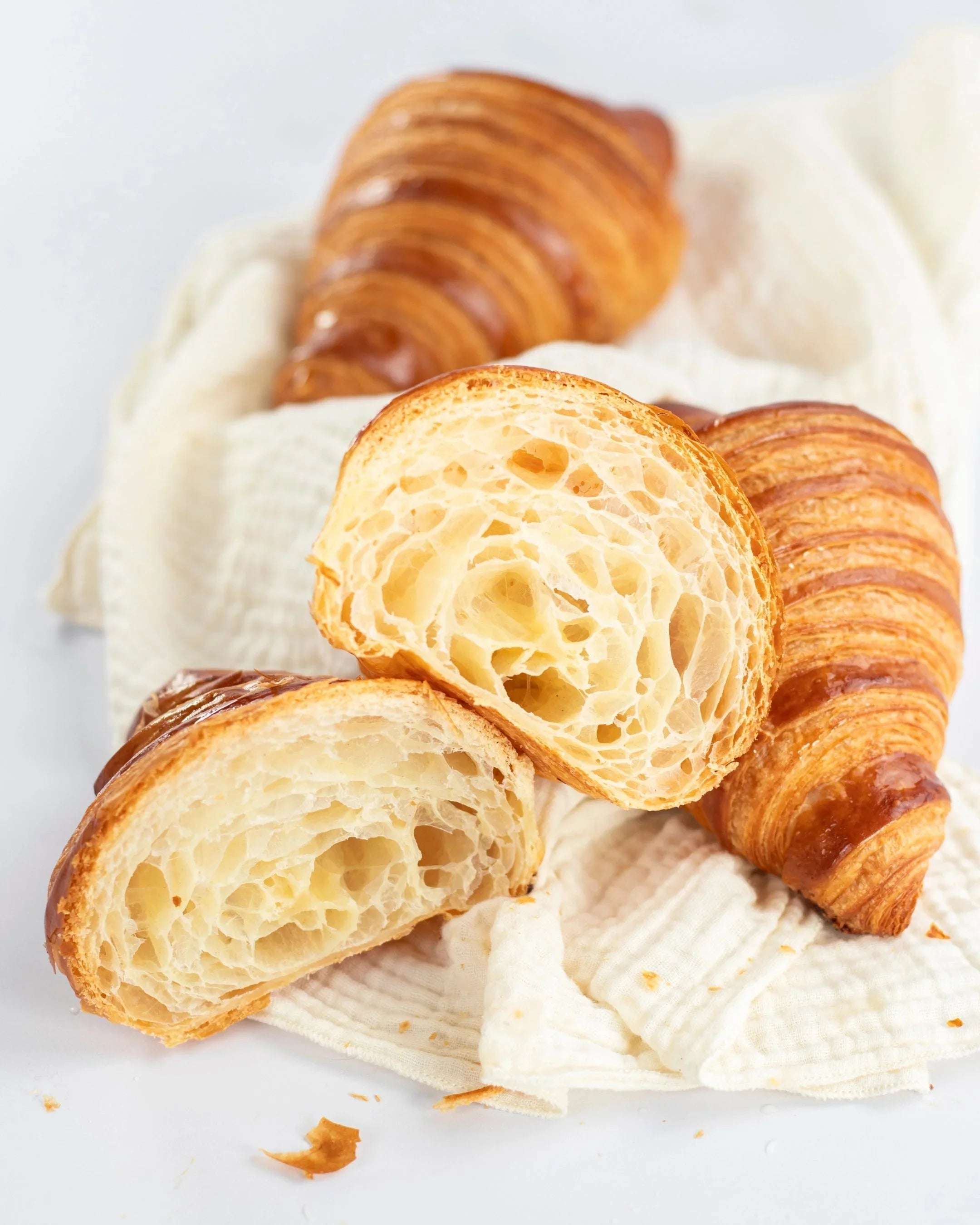 Croissants Maison Vatelier dorés et feuilletés, coupés pour montrer l'alvéolage.