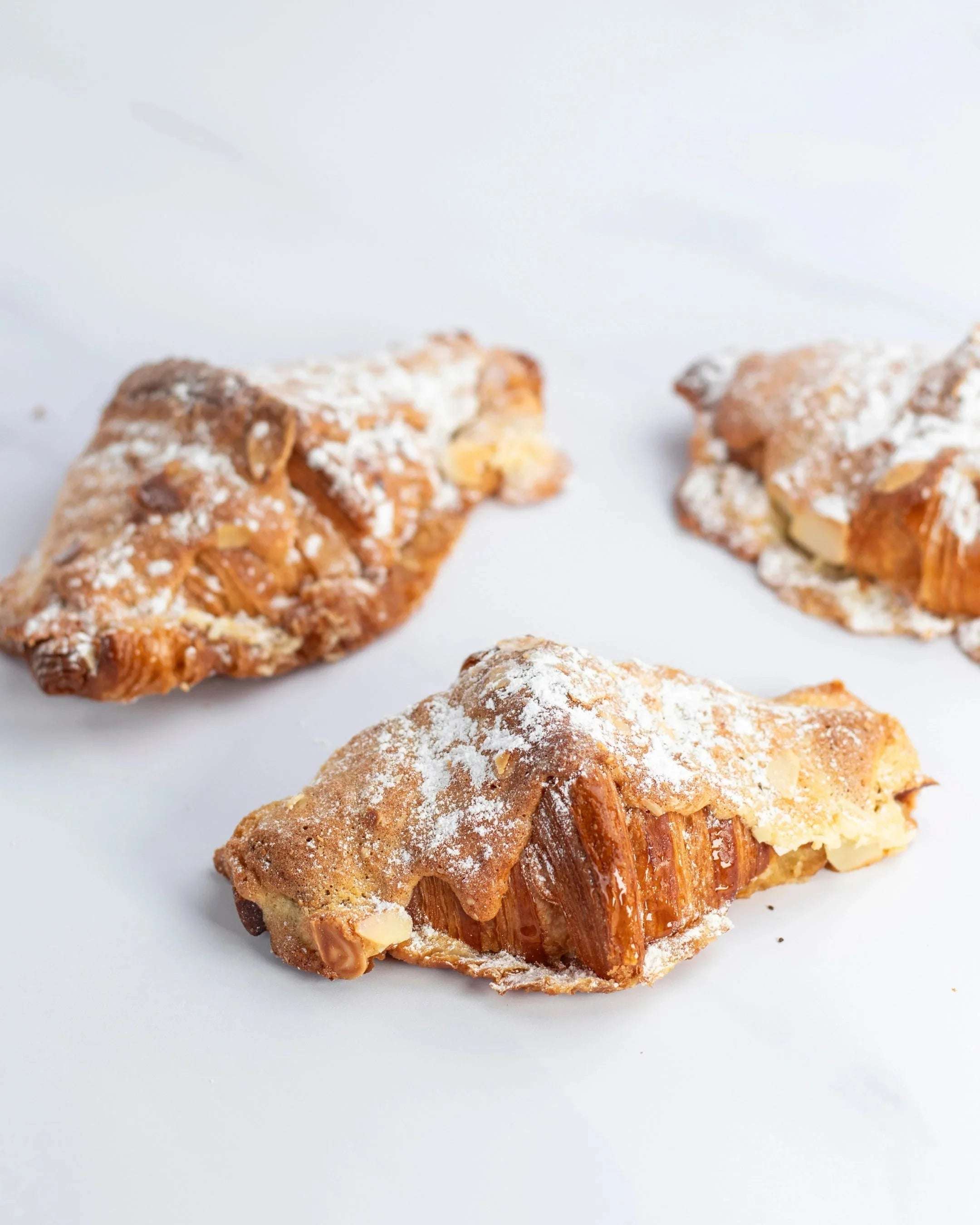 Trois pains au chocolat amande Maison Vatelier saupoudrés de sucre glace.