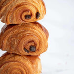 Pile de trois pains au chocolat feuilletés et dorés de Maison Vatelier.