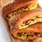 Viennoiseries feuilletées aux pépites de chocolat Maison Vatelier sur planche en bois.
