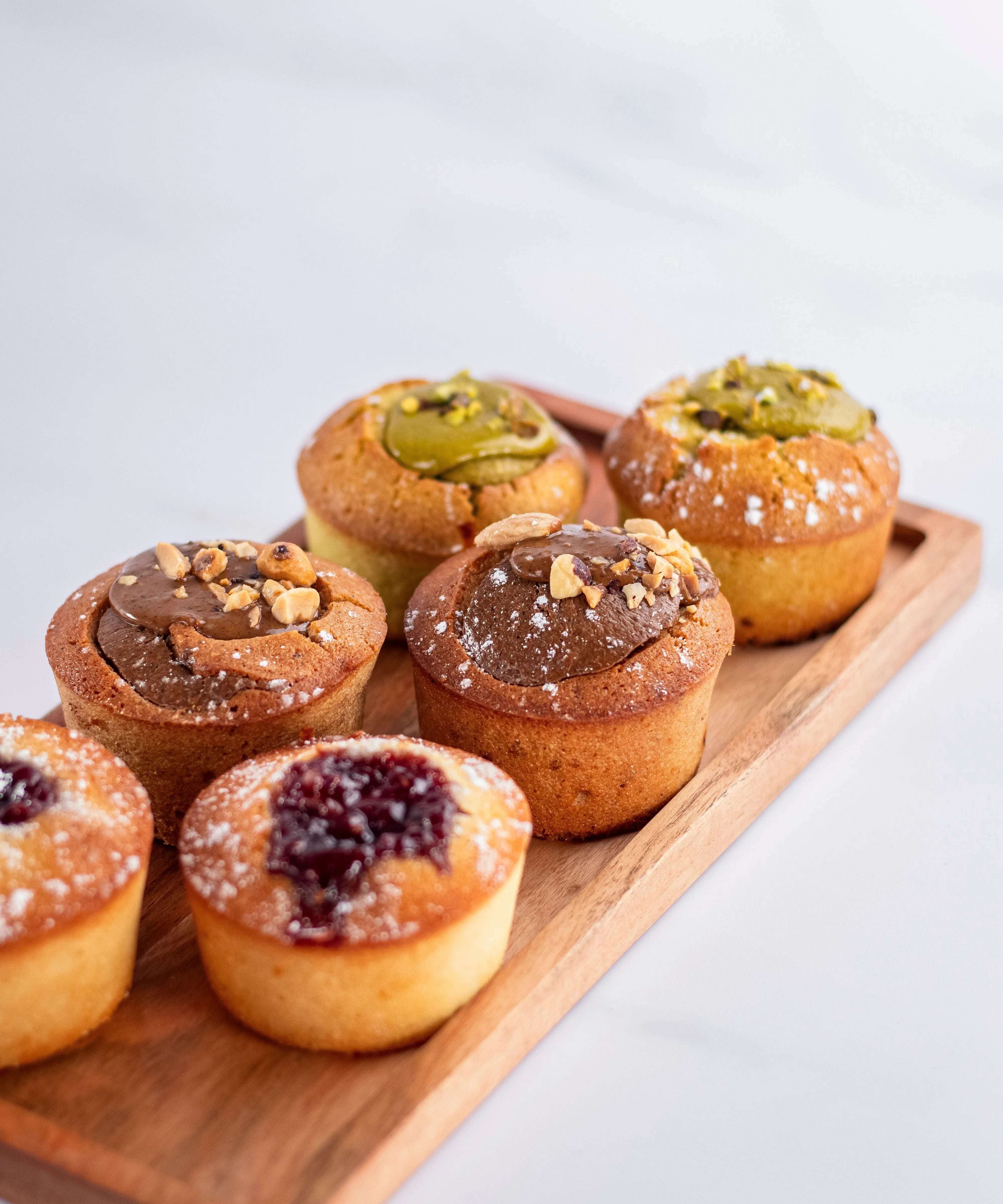 Assortiment de financiers gourmands Maison Vatelier sur un plateau en bois.