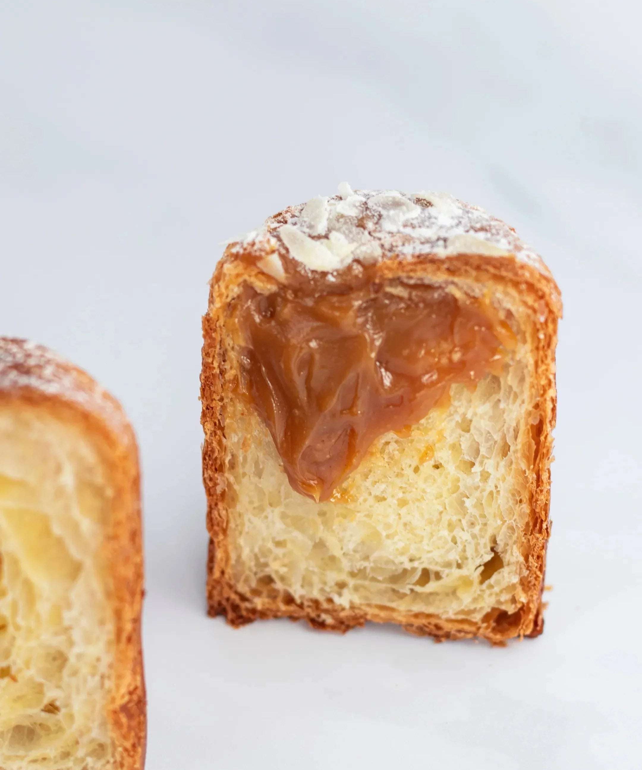 Vue en coupe d'une Briochette Feuilletée au caramel Maison Vatelier, saupoudrée de sucre glace.