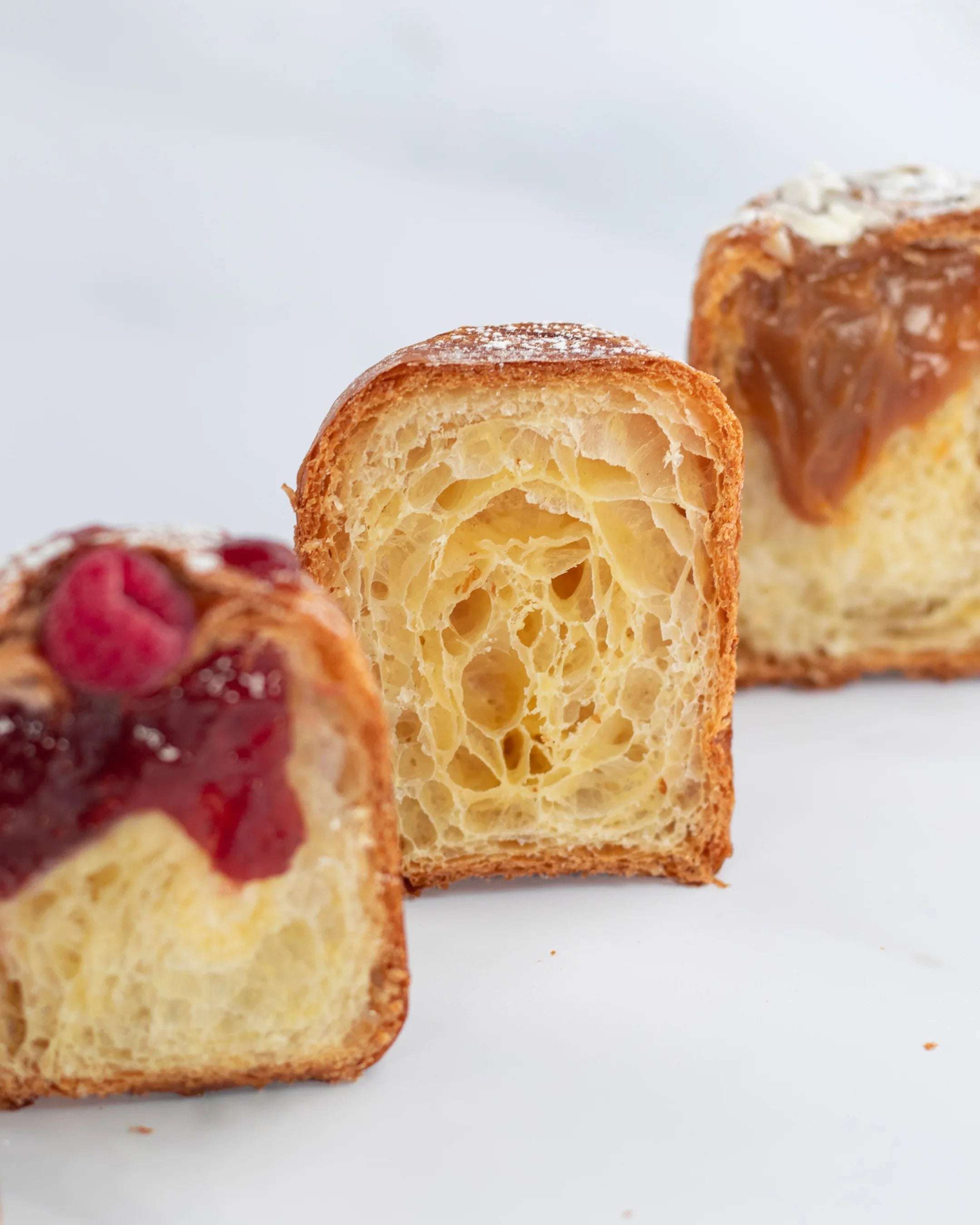 Gros plan de briochettes feuilletées Maison Vatelier, nature, framboise et caramel.