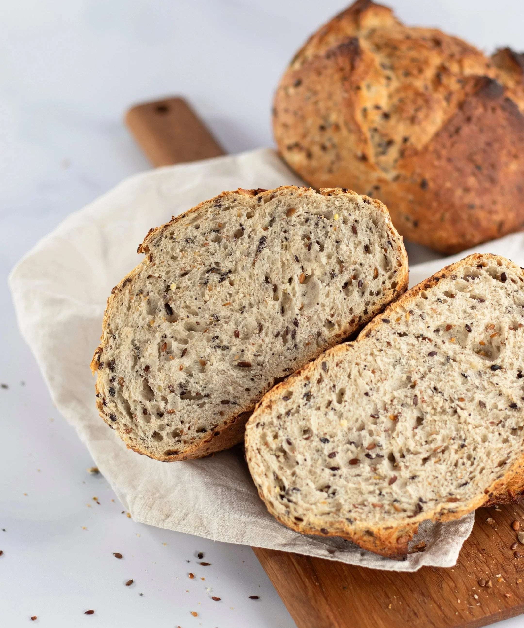 Tranches de pain aux 6 céréales Maison Vatelier sur une planche en bois.