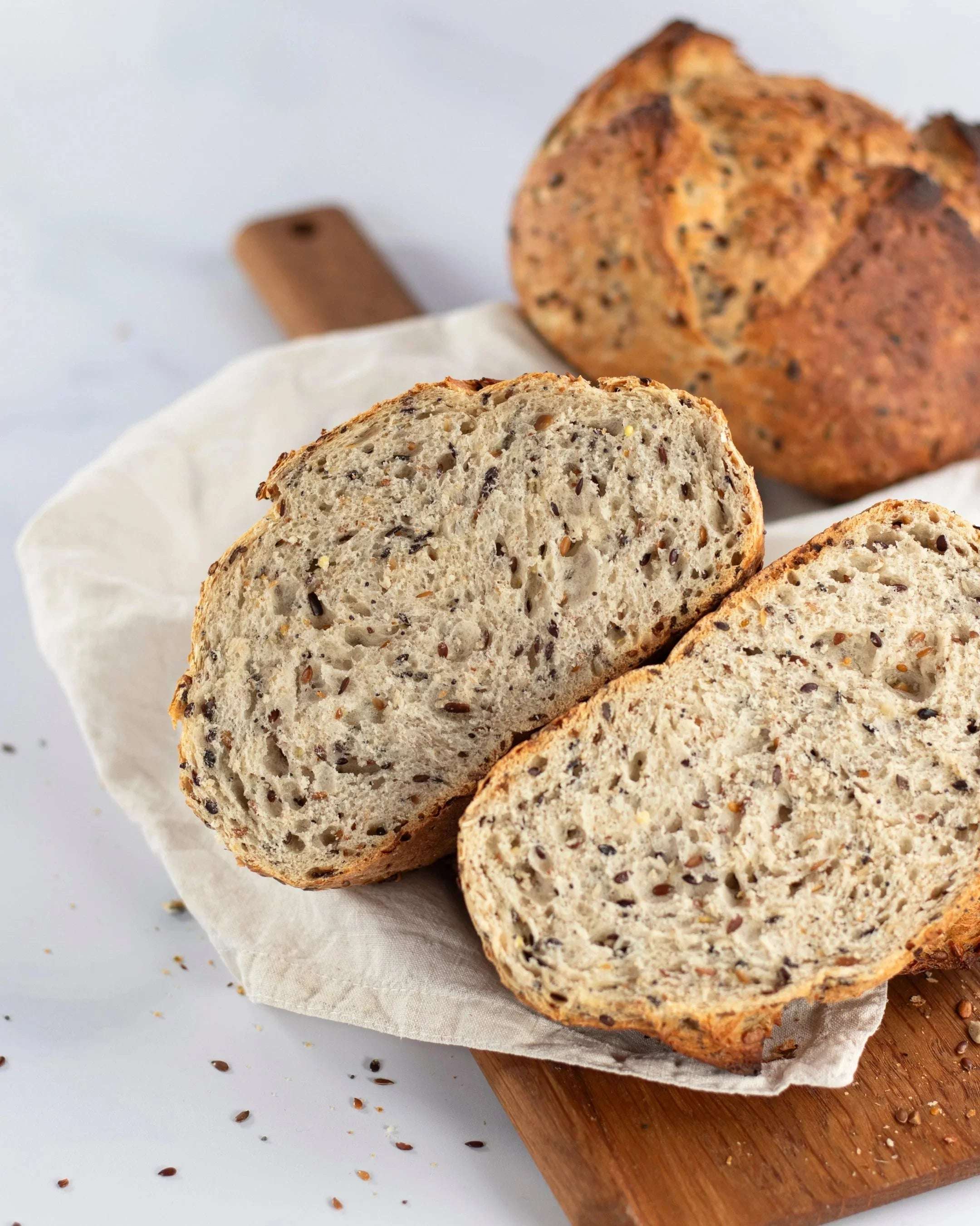 Tranches de pain aux 6 céréales Maison Vatelier sur une planche en bois.
