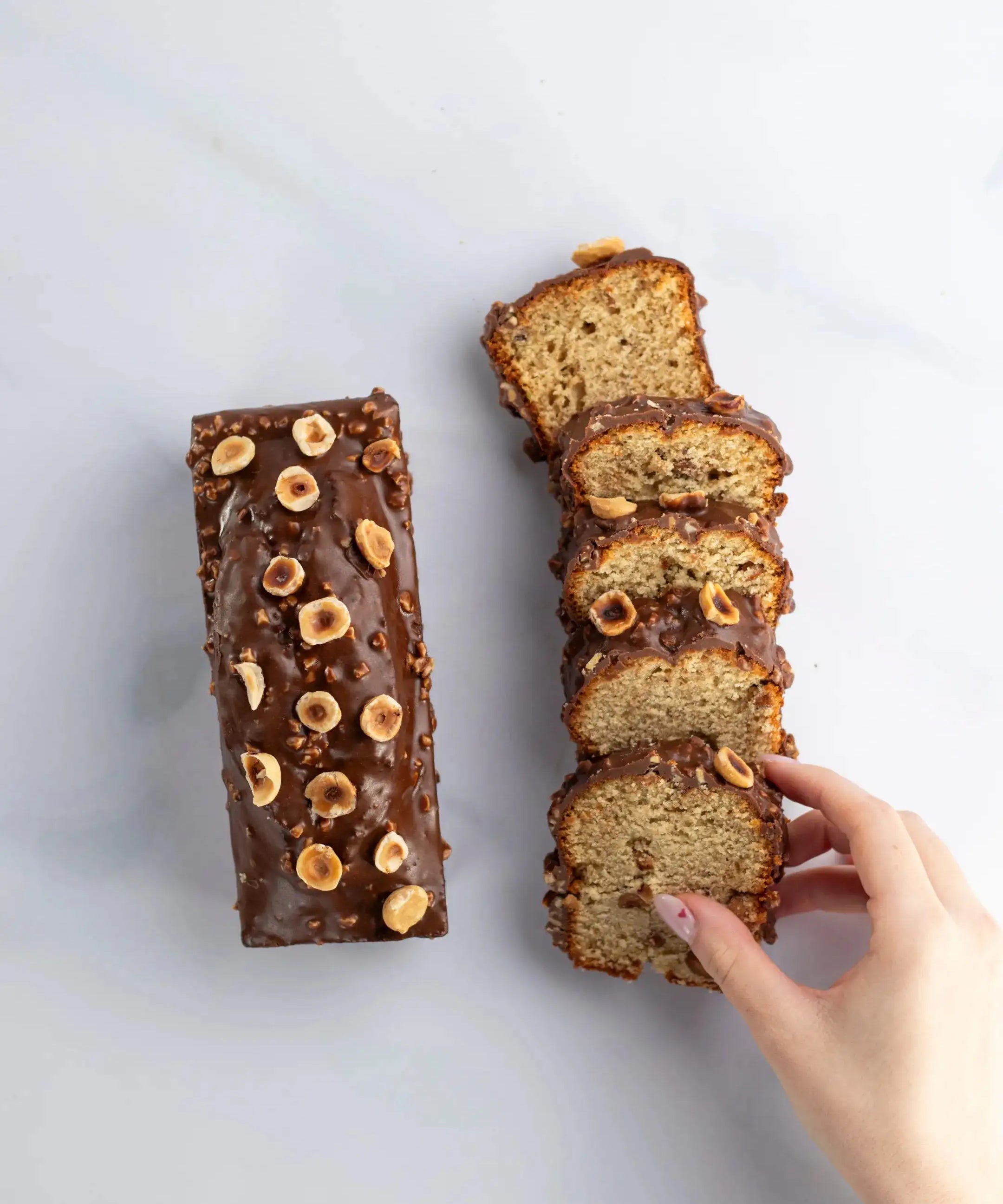 Cake au chocolat au lait et praliné Maison Vatelier, nappage chocolat et noisettes entières.