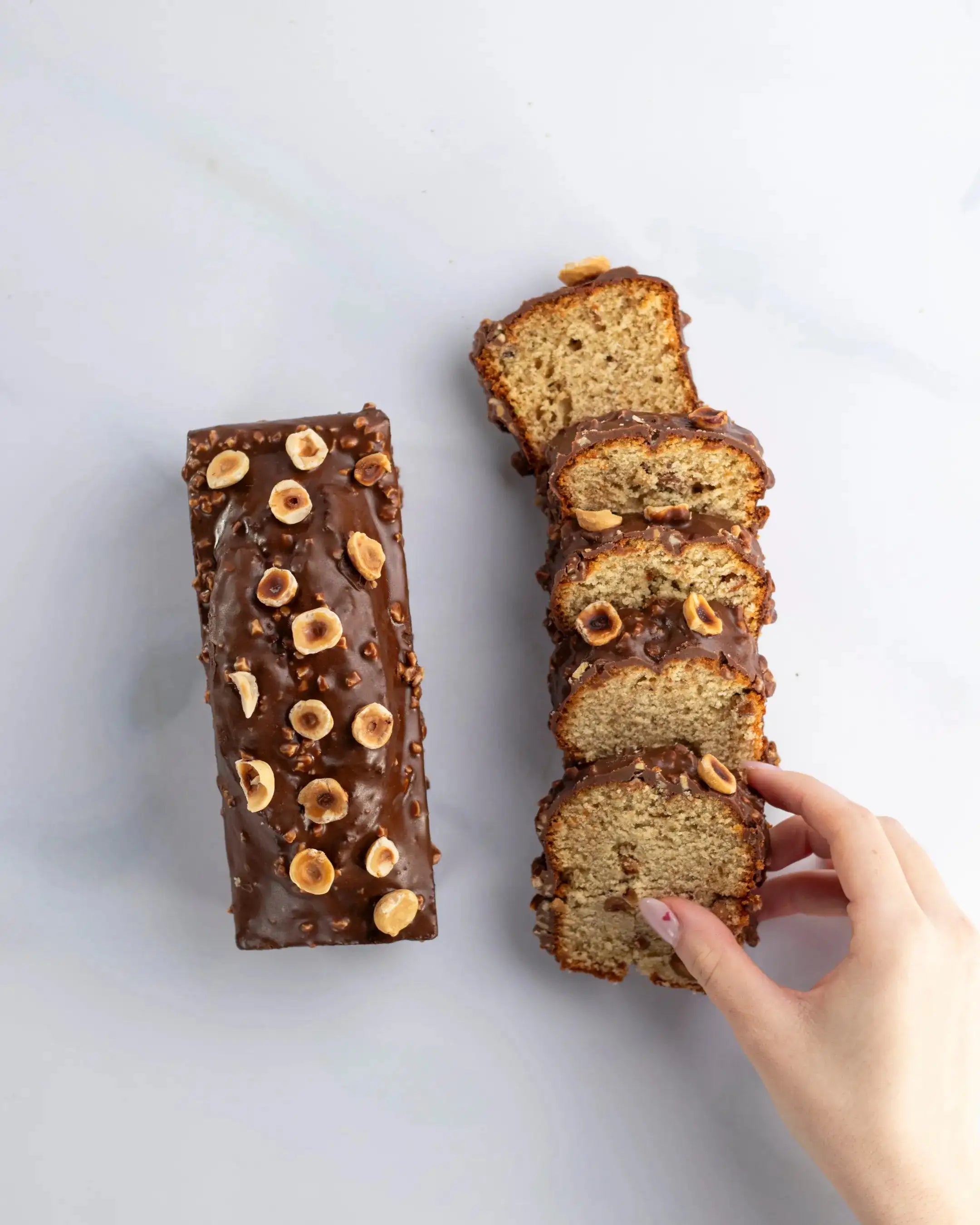 Cake au chocolat au lait et praliné Maison Vatelier, nappage chocolat et noisettes entières.