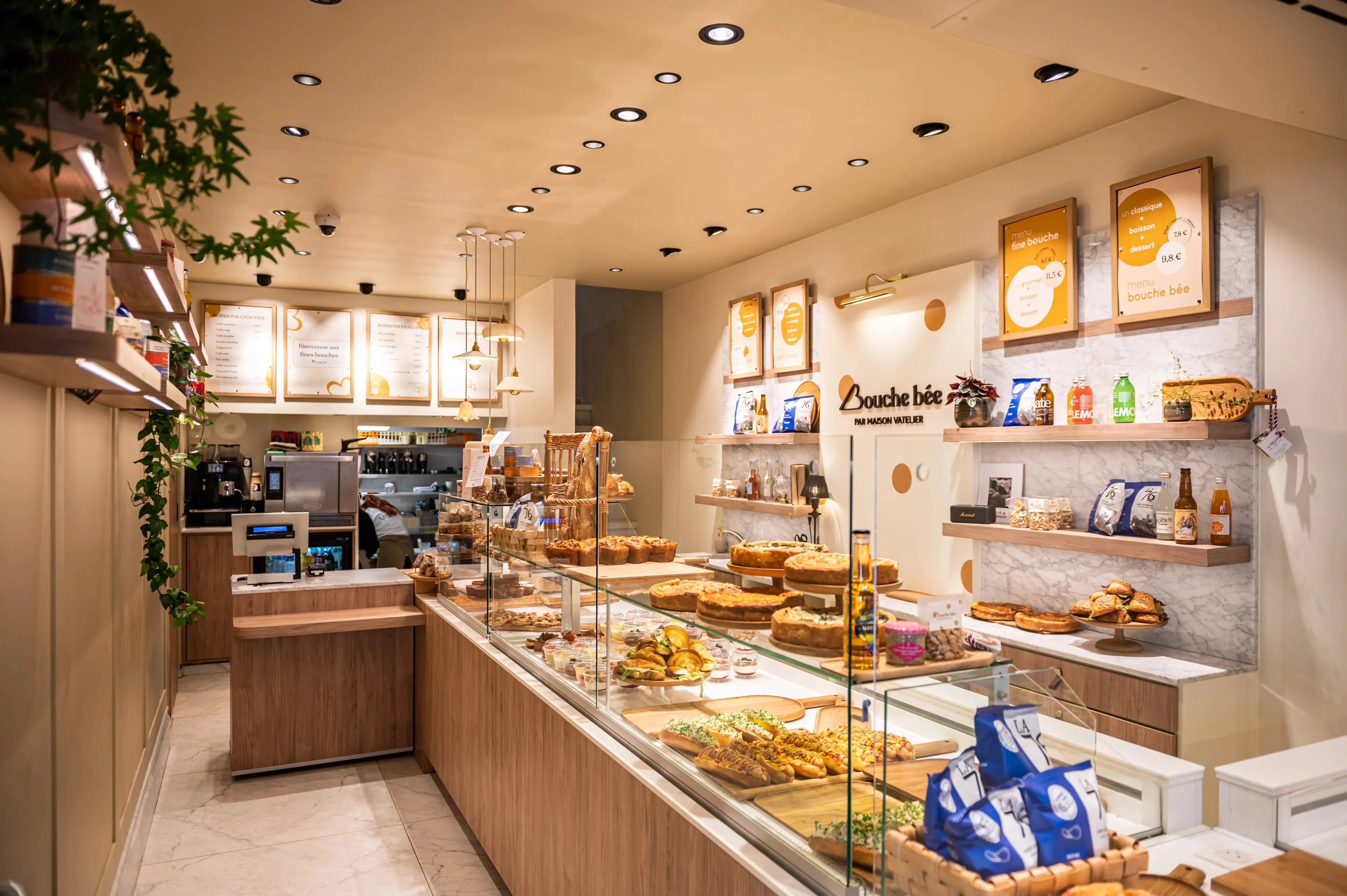 Intérieur d'une pâtisserie avec vitrine exposant des tartes et produits à base de miel.