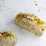 Cake Pistache Griotte de Maison Vatelier glacé au chocolat blanc et éclats de pistaches.