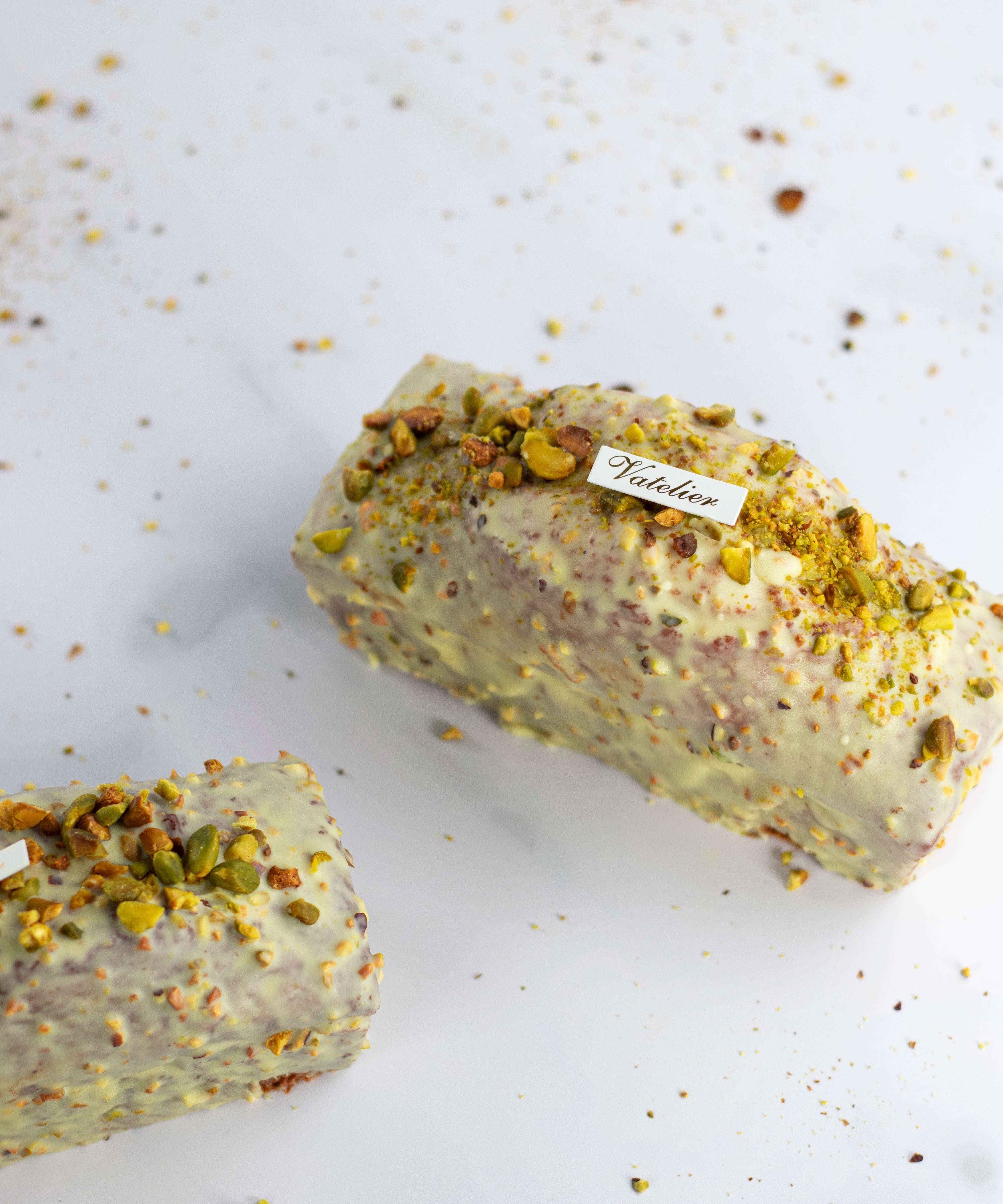 Cake Pistache Griotte de Maison Vatelier glacé au chocolat blanc et éclats de pistaches.