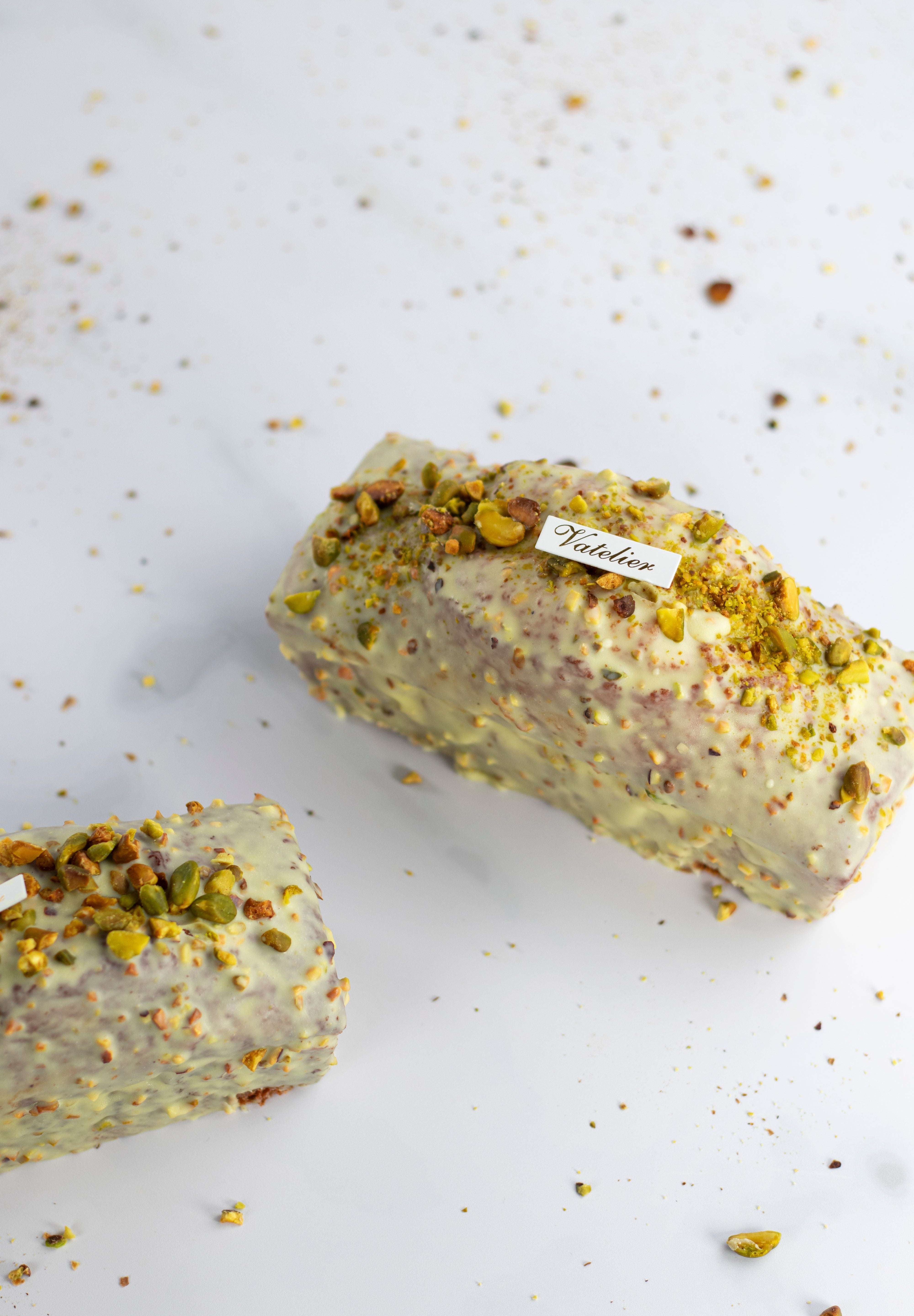 Cake Pistache Griotte de Maison Vatelier glacé au chocolat blanc et éclats de pistaches.