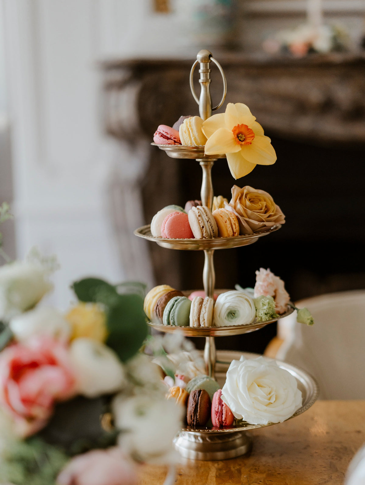 Présentoir à macarons colorés et fleurs fraîches pour un événement gourmand