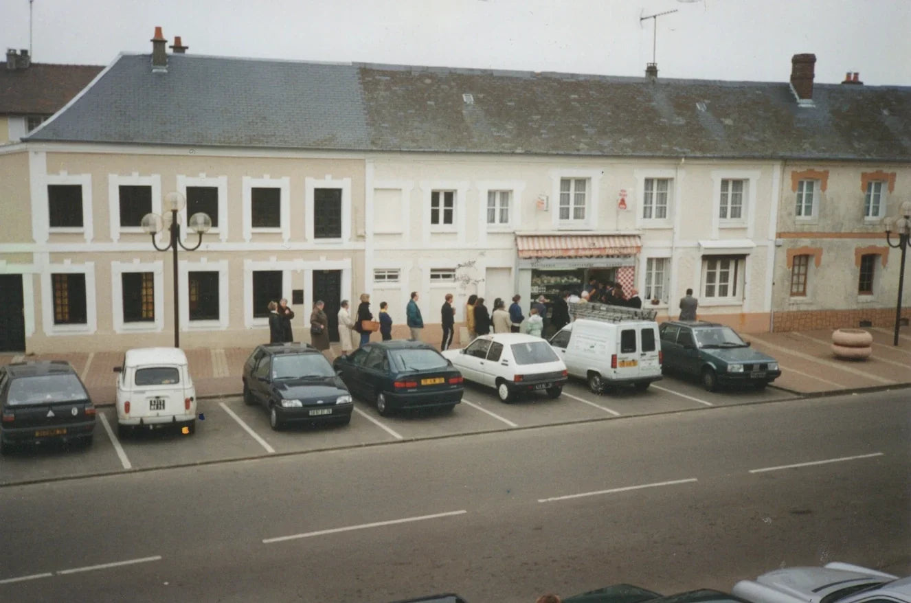 Façade d'une boulangerie-pâtisserie traditionnelle avec voitures garées devant.