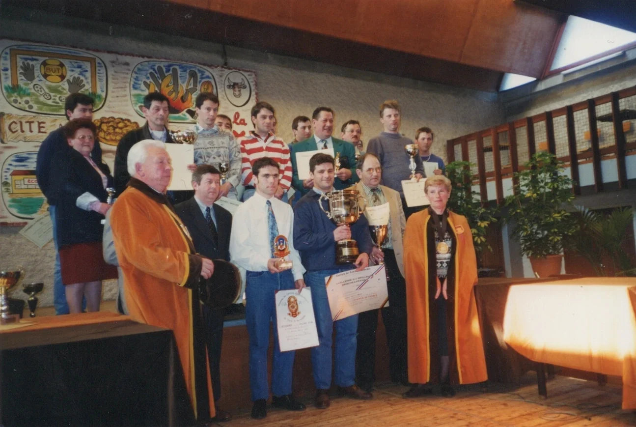 Groupe de personnes célébrant une victoire avec des trophées et des diplômes.