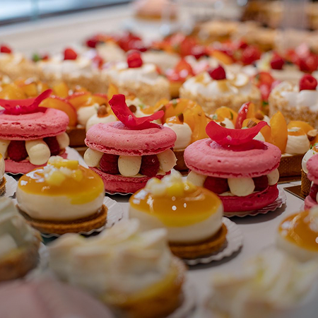 Assortiment de macarons roses aux framboises et tartelettes aux fruits Maison Vatelier