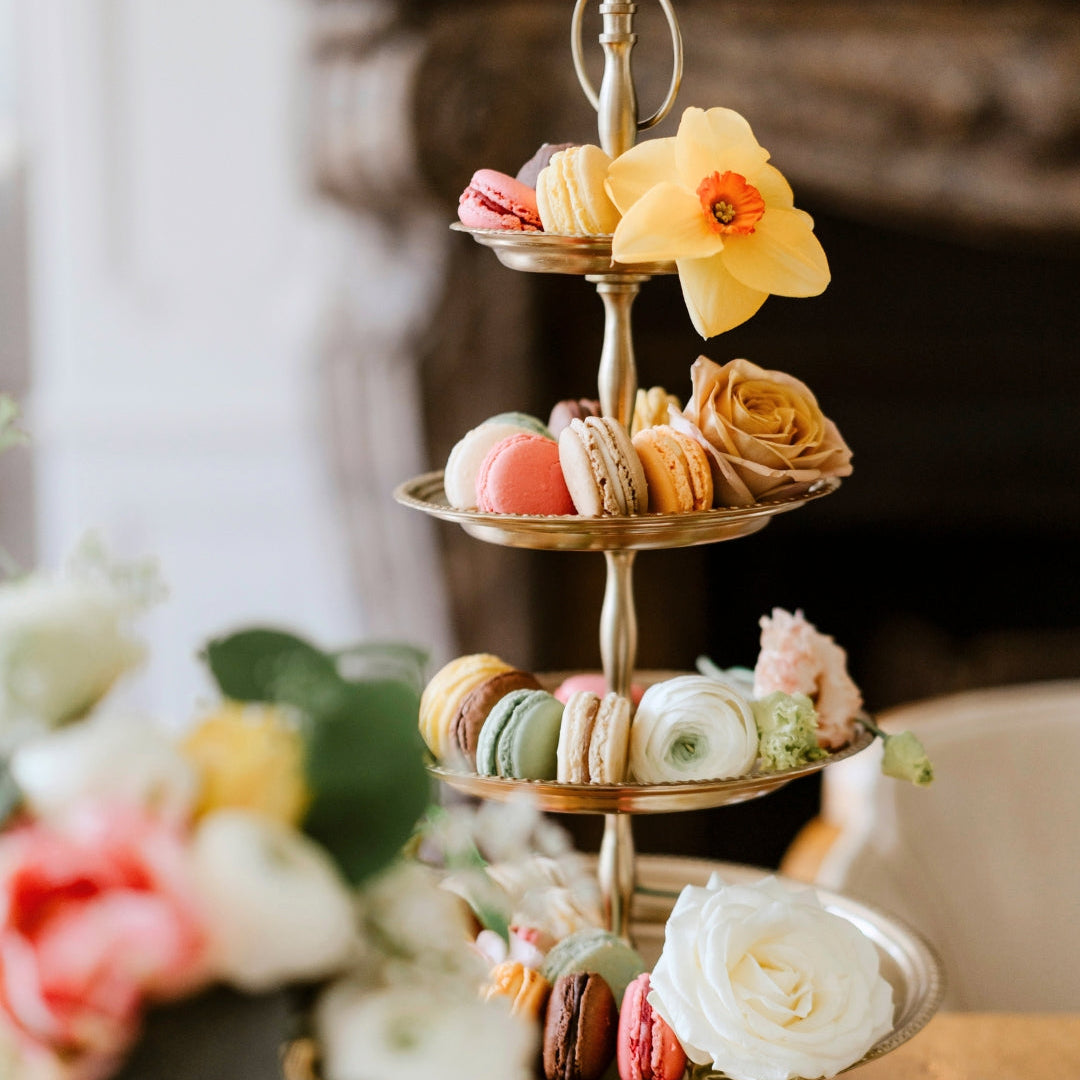 Présentoir à macarons colorés et fleurs fraîches sur plusieurs étages