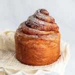 Brioche feuilletée Maison Vatelier saupoudrée de sucre glace sur un support blanc.