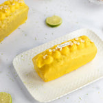 Cake au citron Maison Vatelier avec glaçage jaune et éclats de sel sur plateau blanc.