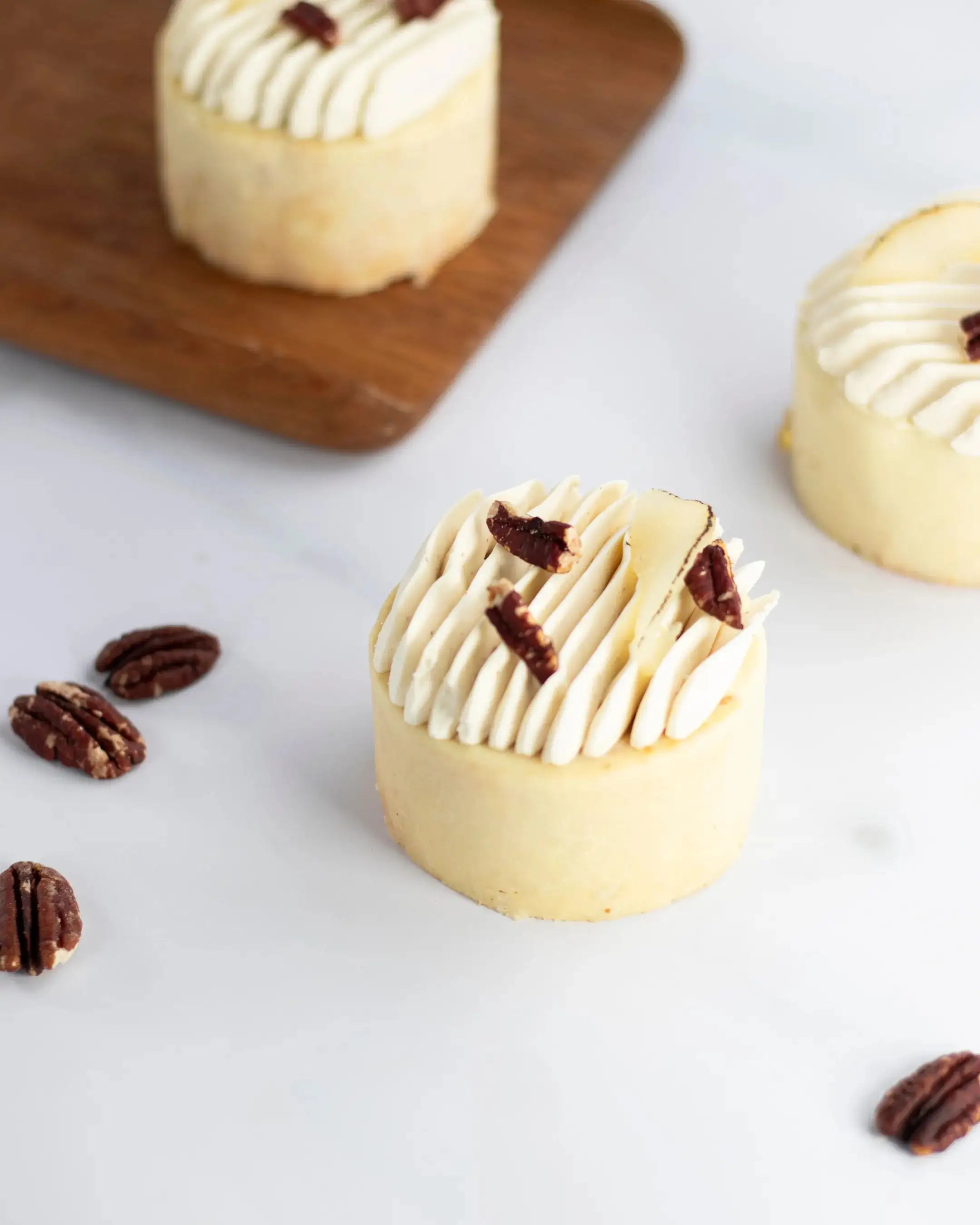 Petit gâteau pâtissier avec crème pochée et éclats de noix de pécan