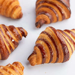 Gros plan de croissants au chocolat Maison Vatelier, dorés et glacés.
