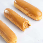 Trois éclairs au café Maison Vatelier avec glaçage caramel, l'un étant entamé.
