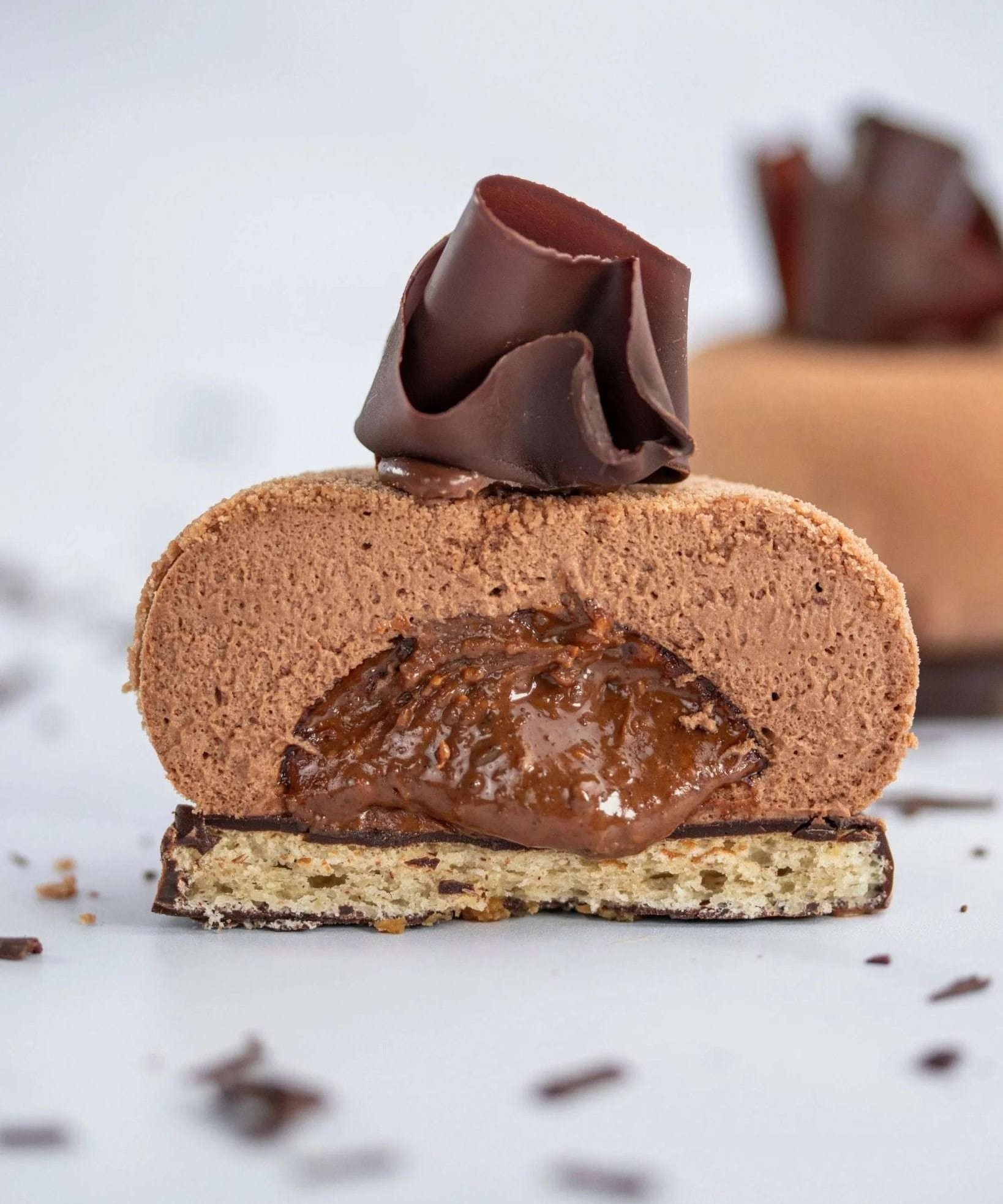Vue en coupe d'un Ecrin praliné Maison Vatelier avec mousse chocolat et cœur fondant.