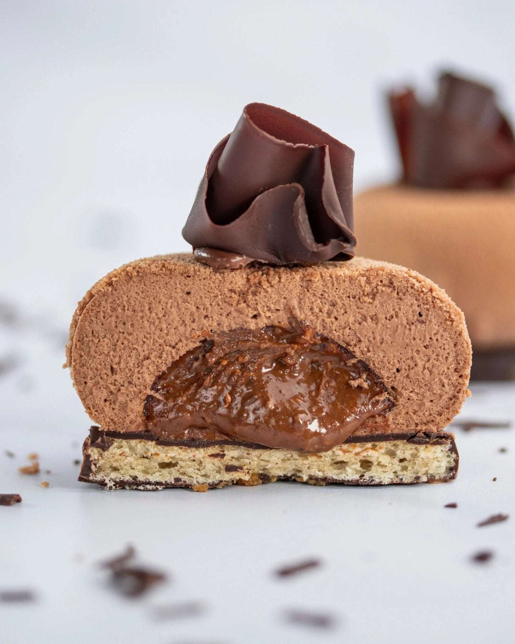 Vue en coupe d'un Ecrin praliné Maison Vatelier avec mousse chocolat et cœur fondant.