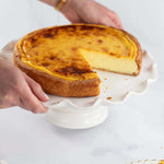 Flan vanille Maison Vatelier sur un support à gâteau blanc avec une part découpée