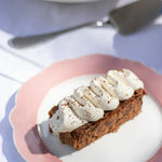 Part de Mille-Feuille praliné tonka Maison Vatelier avec crème chantilly sur assiette rose