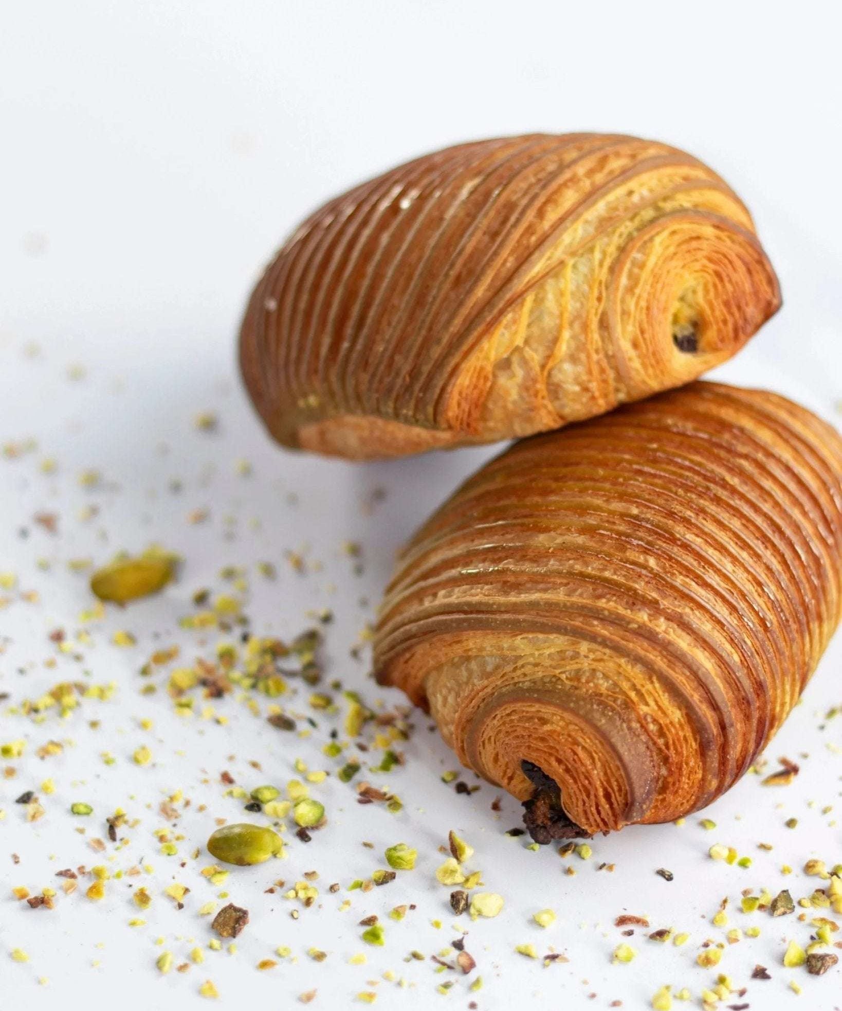 Deux pains au chocolat pistache Maison Vatelier croustillants et feuilletés avec éclats de pistaches.