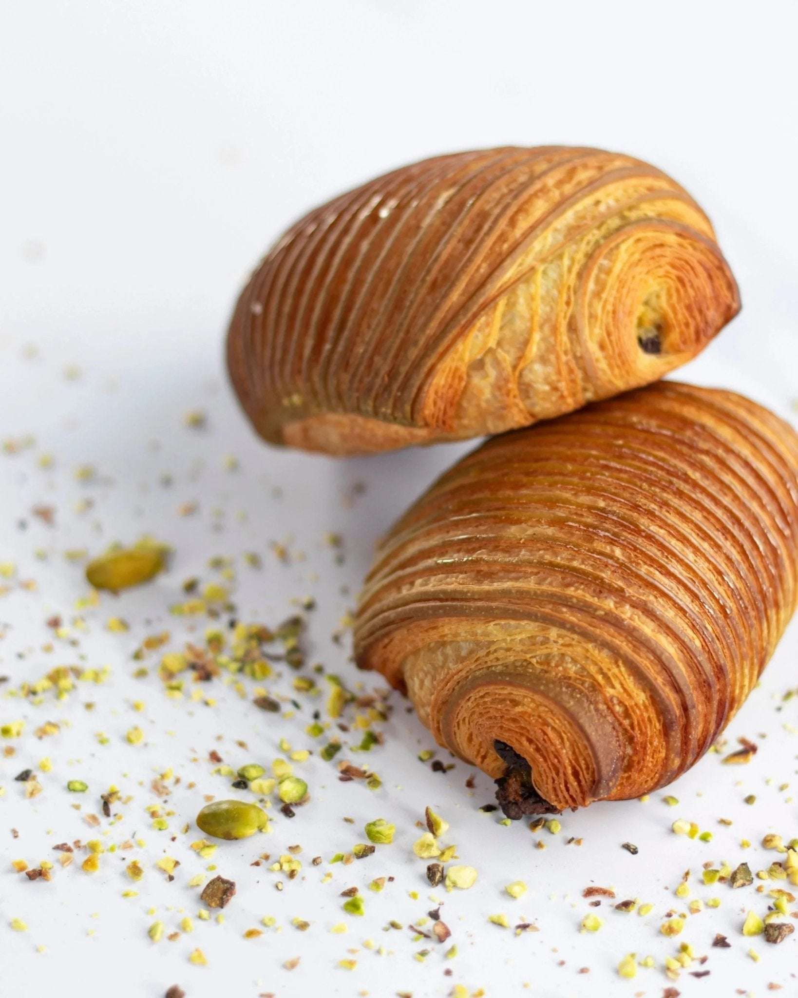 Deux pains au chocolat pistache Maison Vatelier croustillants et feuilletés avec éclats de pistaches.