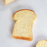 Tranche de pain de mie Maison Vatelier moelleuse sur fond blanc
