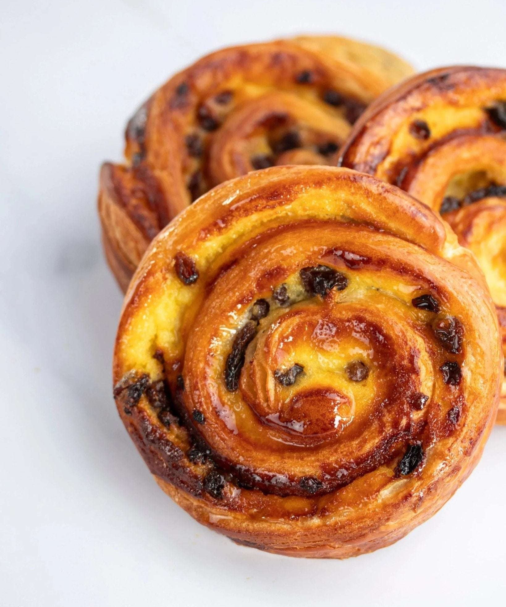 Pain aux raisins Maison Vatelier doré et croustillant avec crème pâtissière et raisins.