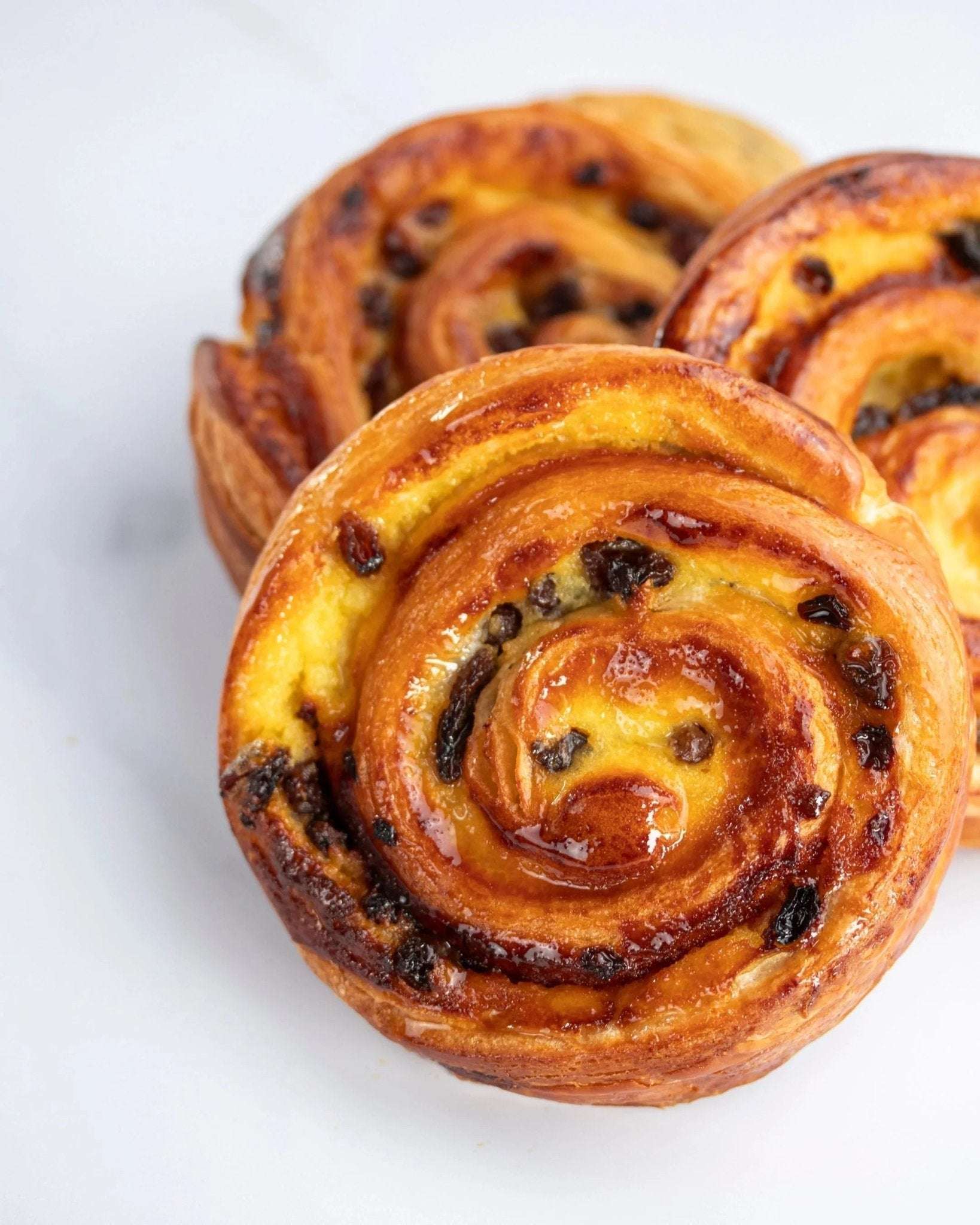 Pain aux raisins Maison Vatelier doré et croustillant avec crème pâtissière et raisins.